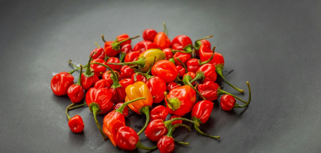 a pile of red and yellow peppers on a black plate