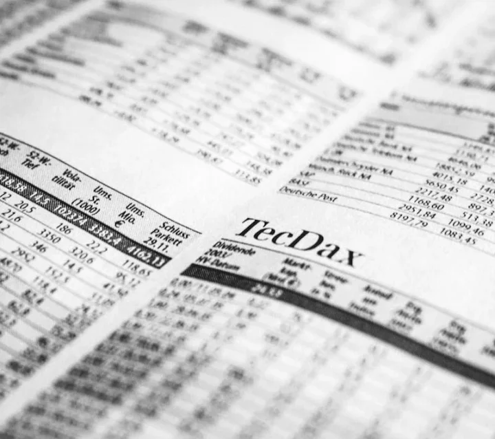 Photo by Markus Spiske Close-up of a printed stock market report in black and white, highlighting stock prices.