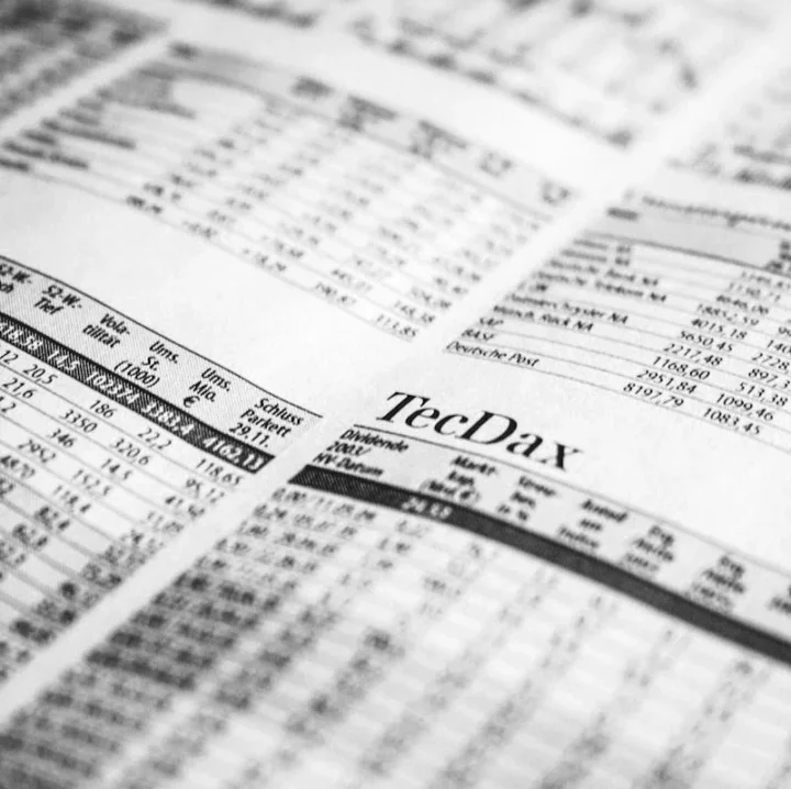 Close-up of a printed stock market report in black and white, highlighting stock prices.