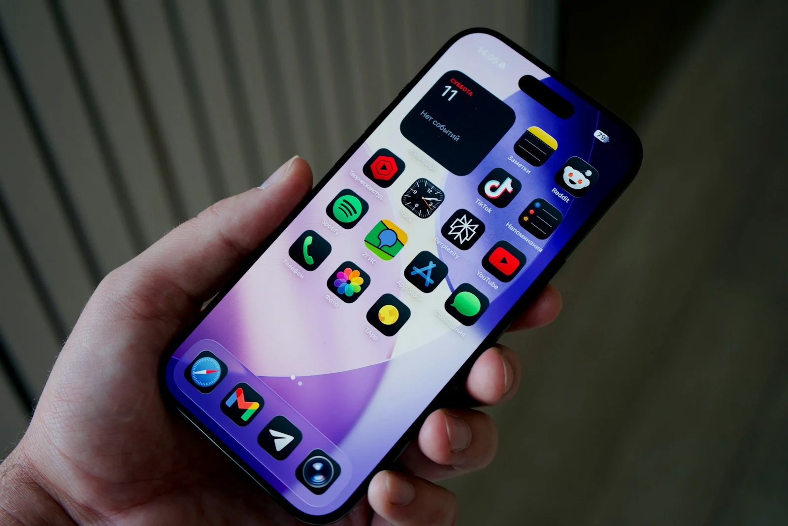 Photo by Georgiy Lyamin Hand holding smartphone with colorful app icons