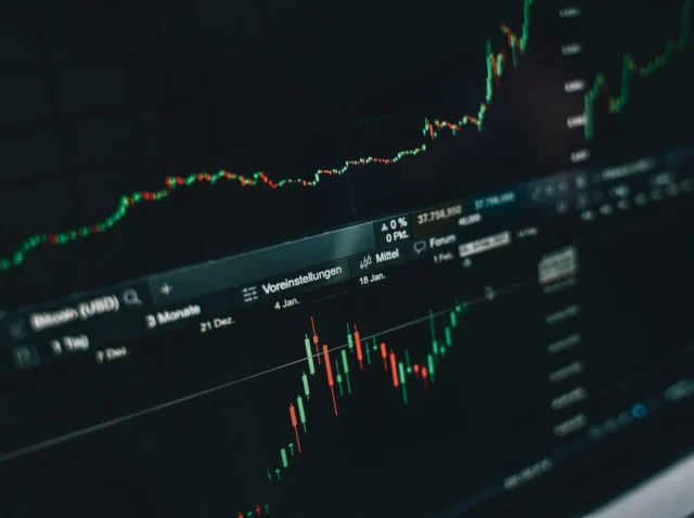 Photo by Alesia Kozik Close-up of a digital market analysis display showing Bitcoin and cryptocurrency price trends.