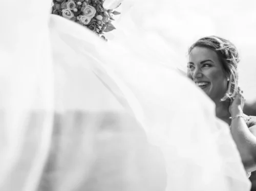 a woman in a wedding dress holding a veil