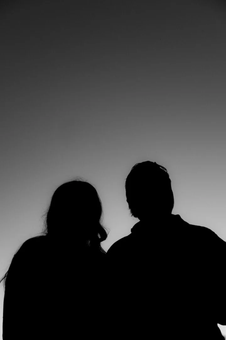Photo by Brooke Balentine Silhouettes of a couple against a gradient sky.
