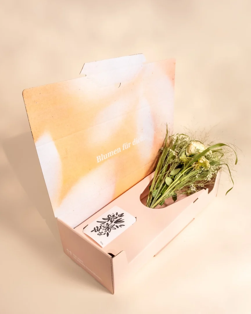Photo by feey Flowers and card in an open delivery box