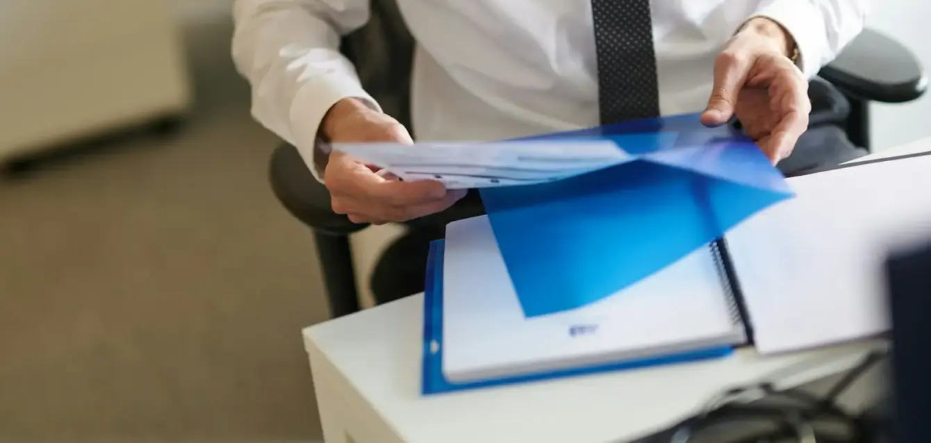 Photo by Invest Europe a man in a white shirt and tie holding a folder