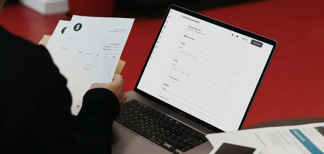 Photo by SumUp A person sitting at a desk with a laptop and papers