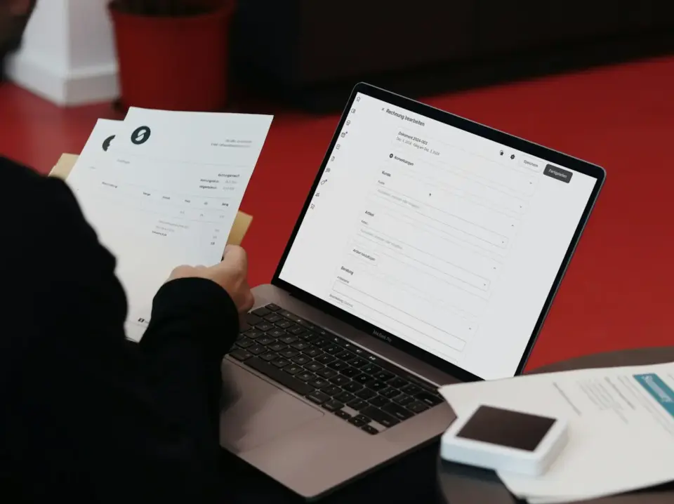 A person sitting at a desk with a laptop and papers